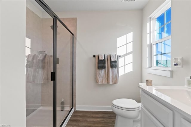 bathroom featuring toilet, hardwood / wood-style flooring, an enclosed shower, and vanity