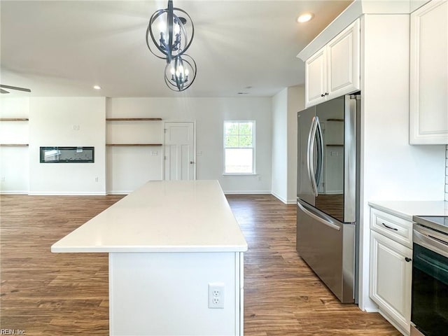 kitchen featuring appliances with stainless steel finishes, a center island, decorative light fixtures, and white cabinetry