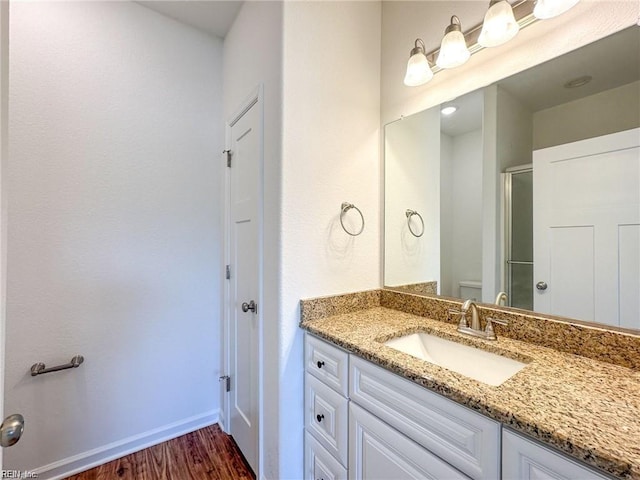 bathroom with vanity, hardwood / wood-style flooring, and a shower with shower door