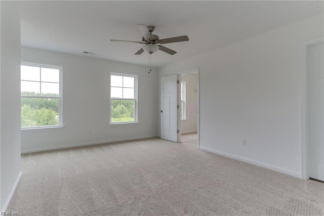 carpeted spare room with plenty of natural light and ceiling fan