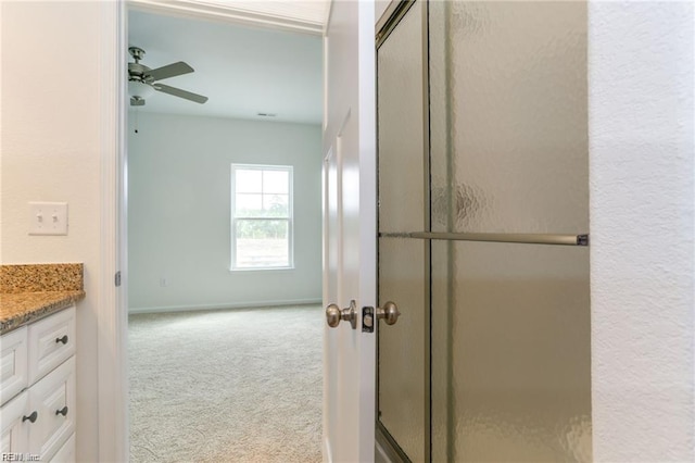 bathroom with ceiling fan, vanity, and a shower with shower door