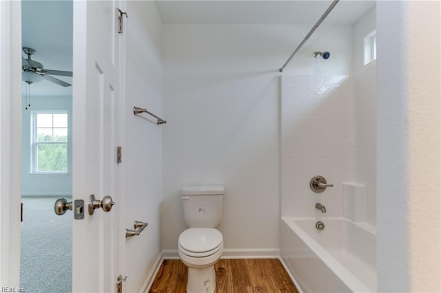 bathroom featuring hardwood / wood-style flooring, ceiling fan, toilet, and shower / bath combination