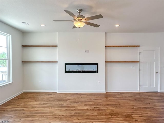 unfurnished living room featuring hardwood / wood-style flooring and ceiling fan