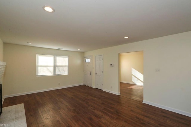 unfurnished living room featuring a fireplace and dark hardwood / wood-style flooring