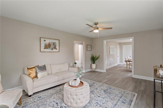 living room featuring ceiling fan and wood-type flooring