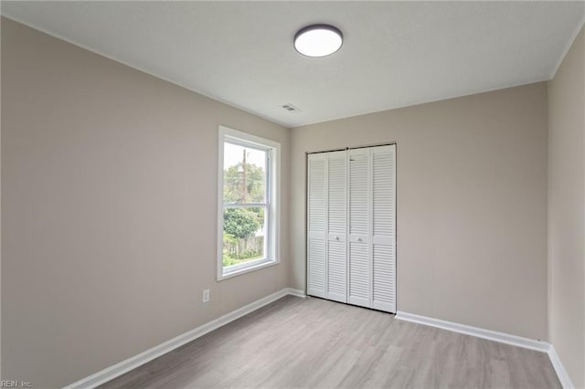 unfurnished bedroom with a closet and light hardwood / wood-style flooring