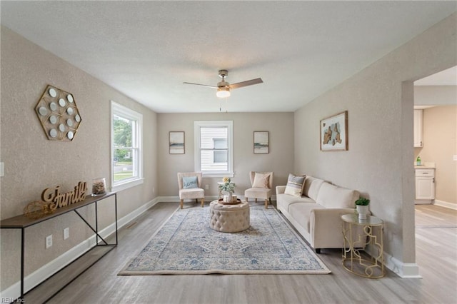 living room featuring ceiling fan and light hardwood / wood-style floors