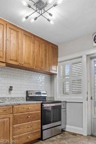 kitchen featuring decorative backsplash, a chandelier, light stone counters, and stainless steel range with electric stovetop