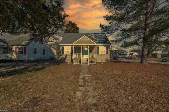 bungalow featuring a porch and a yard