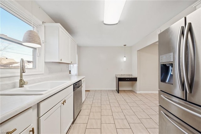 kitchen featuring appliances with stainless steel finishes, white cabinetry, hanging light fixtures, and sink