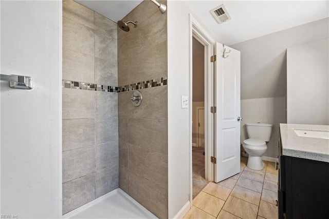 bathroom with tiled shower, tile patterned floors, vanity, and toilet