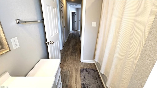 corridor with dark hardwood / wood-style flooring