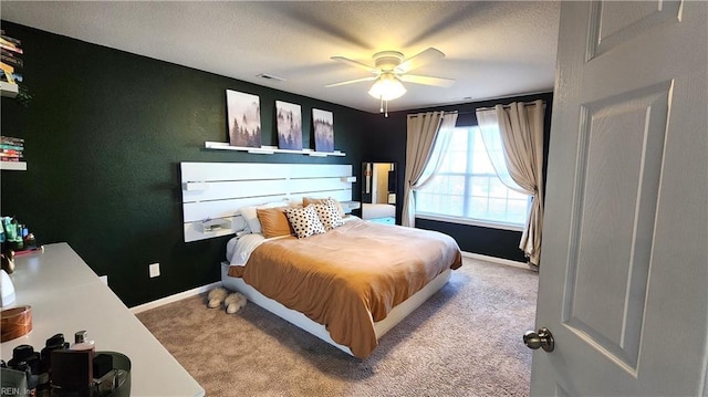 bedroom featuring a textured ceiling, ceiling fan, and light carpet