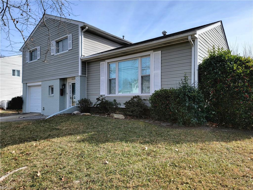 split level home with a front yard and a garage