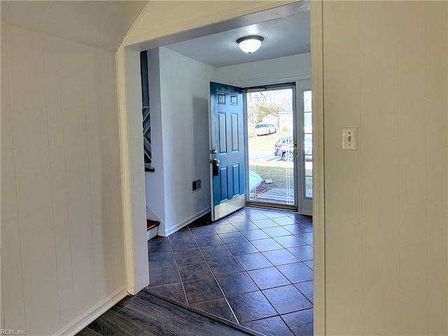 entryway with dark tile patterned floors