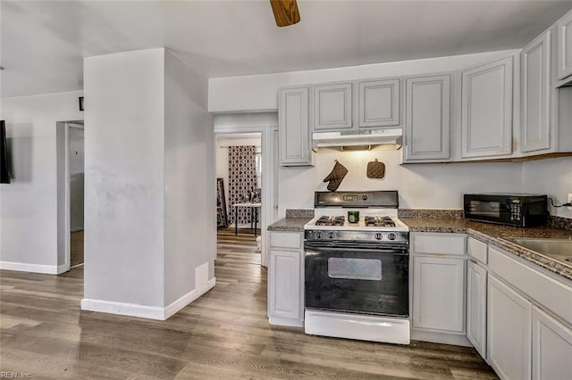 kitchen featuring ceiling fan, dark hardwood / wood-style flooring, white range oven, and sink