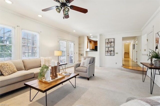 living room with light colored carpet, ceiling fan, and ornamental molding