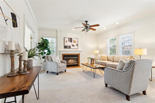 living room featuring light colored carpet, ceiling fan, and ornamental molding