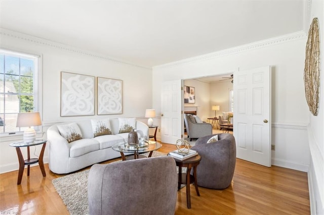 living room with ceiling fan, crown molding, and hardwood / wood-style flooring