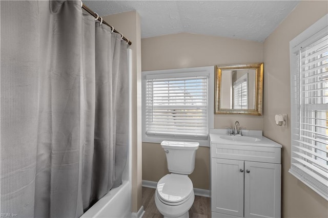 bathroom featuring toilet, a textured ceiling, wood finished floors, vanity, and vaulted ceiling