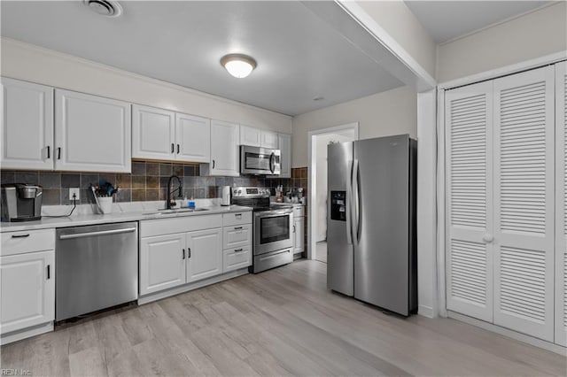 kitchen with white cabinets, sink, appliances with stainless steel finishes, and tasteful backsplash