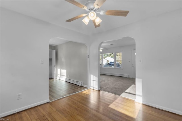 unfurnished room featuring hardwood / wood-style flooring, baseboard heating, and ceiling fan