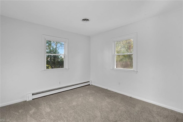 carpeted spare room with a baseboard heating unit