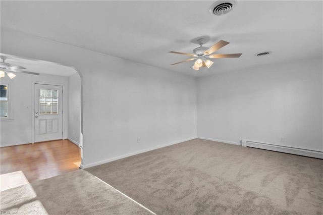 carpeted empty room featuring baseboard heating and ceiling fan