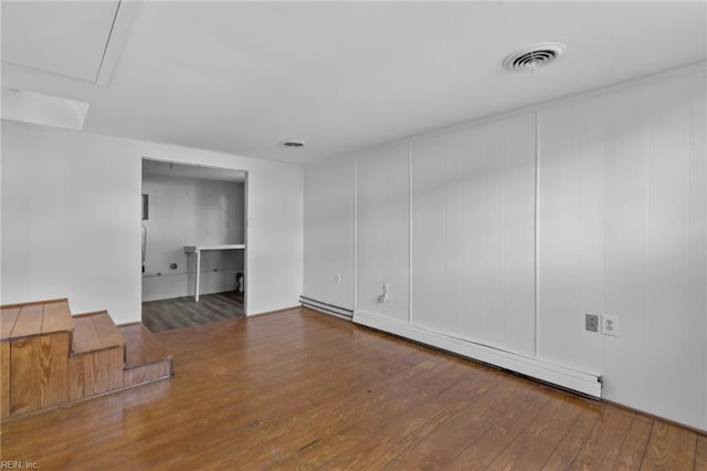 spare room with wood-type flooring and a baseboard heating unit