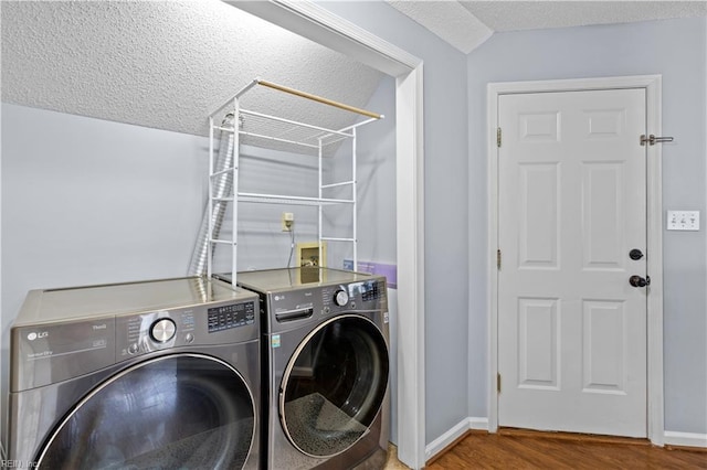 laundry room with hardwood / wood-style floors, washer and dryer, and a textured ceiling