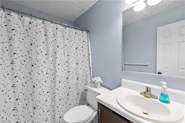 bathroom with a shower with curtain, vanity, a textured ceiling, and toilet