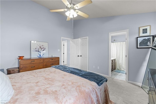 carpeted bedroom with ensuite bathroom, ceiling fan, and lofted ceiling