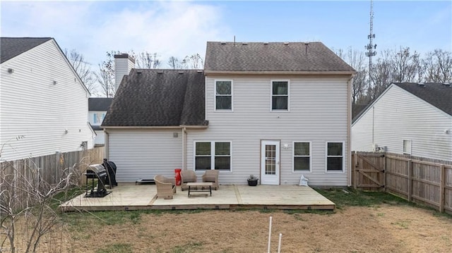 back of property with a yard and a wooden deck