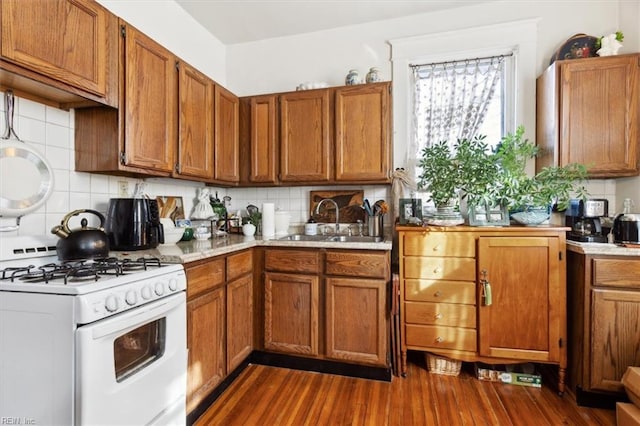 kitchen featuring decorative backsplash, white gas range, sink, and dark wood-type flooring