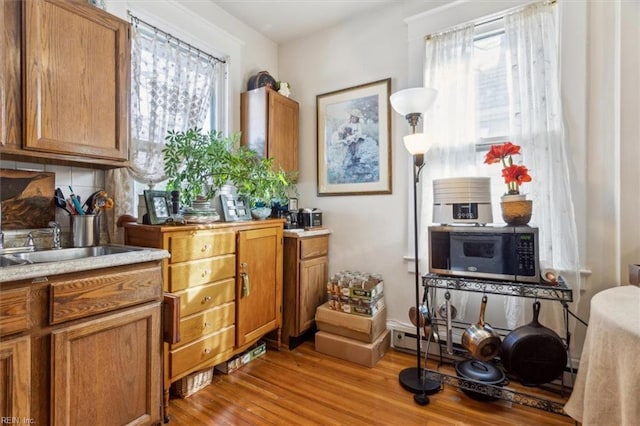 interior space featuring backsplash, light hardwood / wood-style floors, and sink