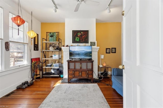 living area with ceiling fan, rail lighting, and hardwood / wood-style flooring