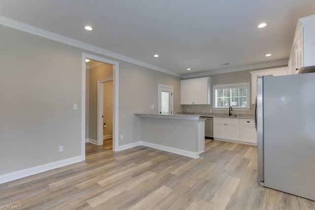 kitchen with kitchen peninsula, white cabinetry, stainless steel appliances, and ornamental molding