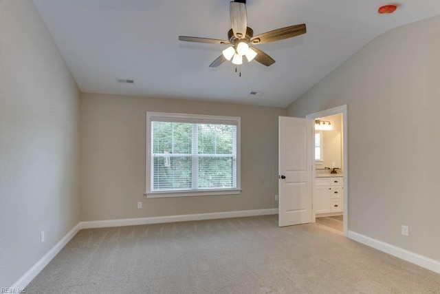 empty room with light carpet, ceiling fan, and vaulted ceiling