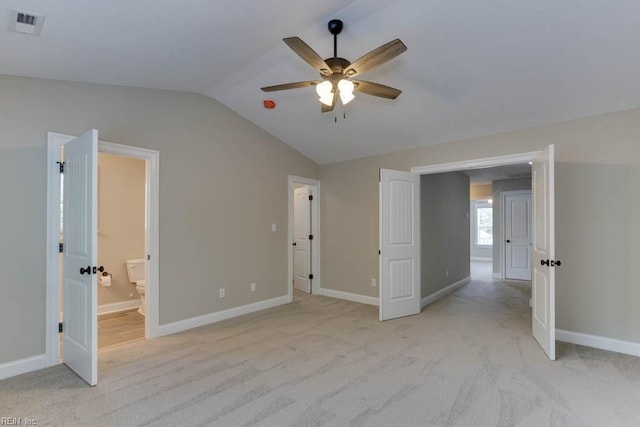 unfurnished bedroom featuring connected bathroom, ceiling fan, light colored carpet, and lofted ceiling