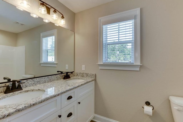 bathroom with vanity, toilet, and a wealth of natural light