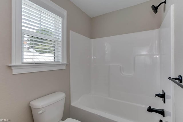 bathroom with washtub / shower combination and toilet