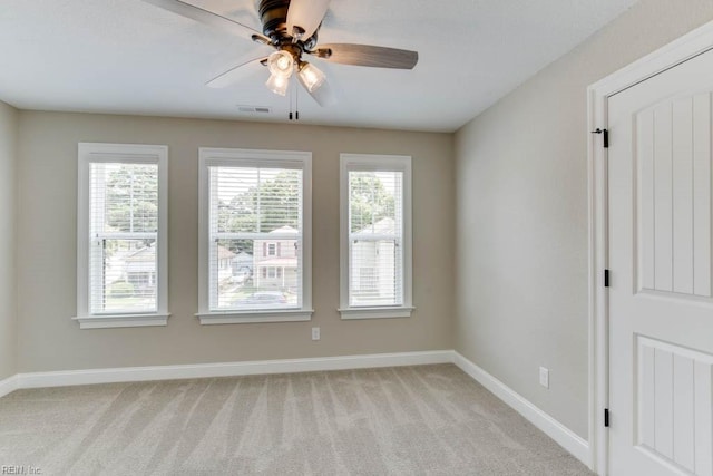 carpeted spare room with plenty of natural light and ceiling fan