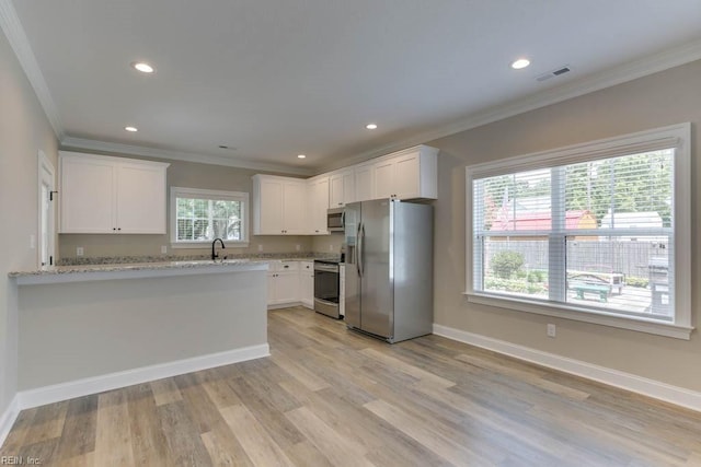 kitchen featuring a healthy amount of sunlight, light stone counters, white cabinetry, and appliances with stainless steel finishes