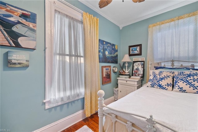 bedroom featuring ceiling fan, dark hardwood / wood-style flooring, and crown molding