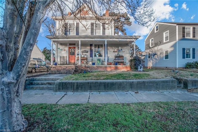 view of front of house featuring covered porch and a front lawn