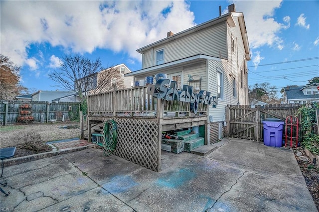 rear view of house featuring a patio and a wooden deck