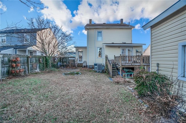 back of house with central air condition unit and a wooden deck