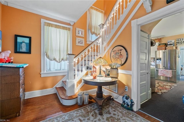 stairs featuring hardwood / wood-style flooring and crown molding