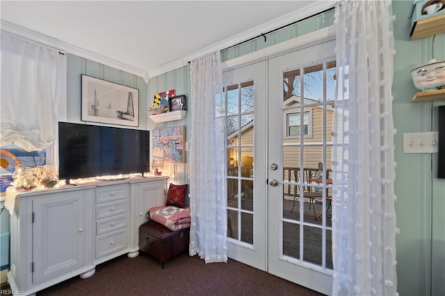 interior space with french doors, dark carpet, and ornamental molding