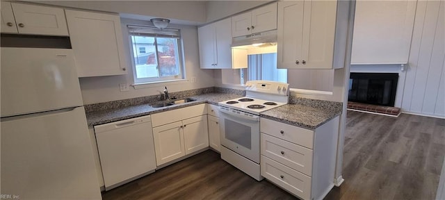 kitchen featuring white appliances, white cabinets, sink, a fireplace, and dark hardwood / wood-style flooring